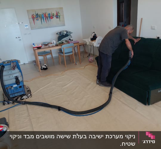 אדם מנקה ספה עם מכונת ניקוי מקצועית